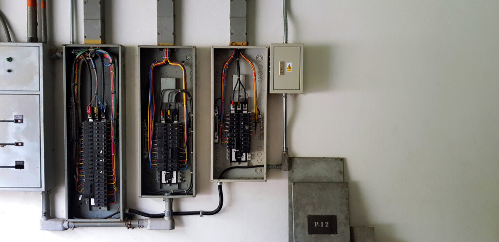 Many circuit breaker for distribute electricity in building on white wall with right copy space in main electrical room.